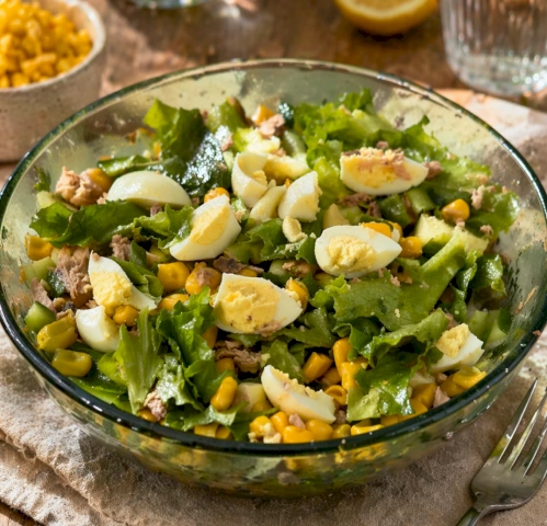 На дно тарелки выложите или аккуратно порвите листья салата 